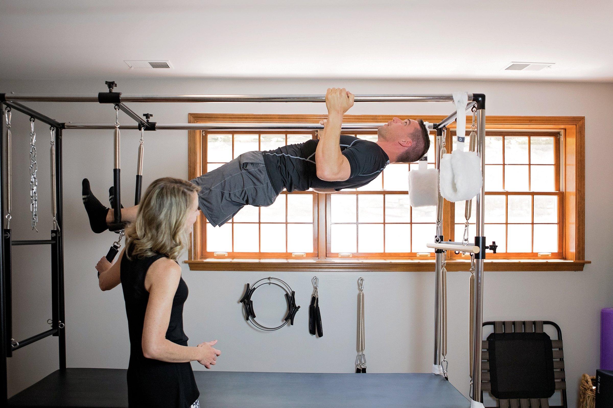 A client performing an advanced inversion on the Cadillac with Laura's guidance